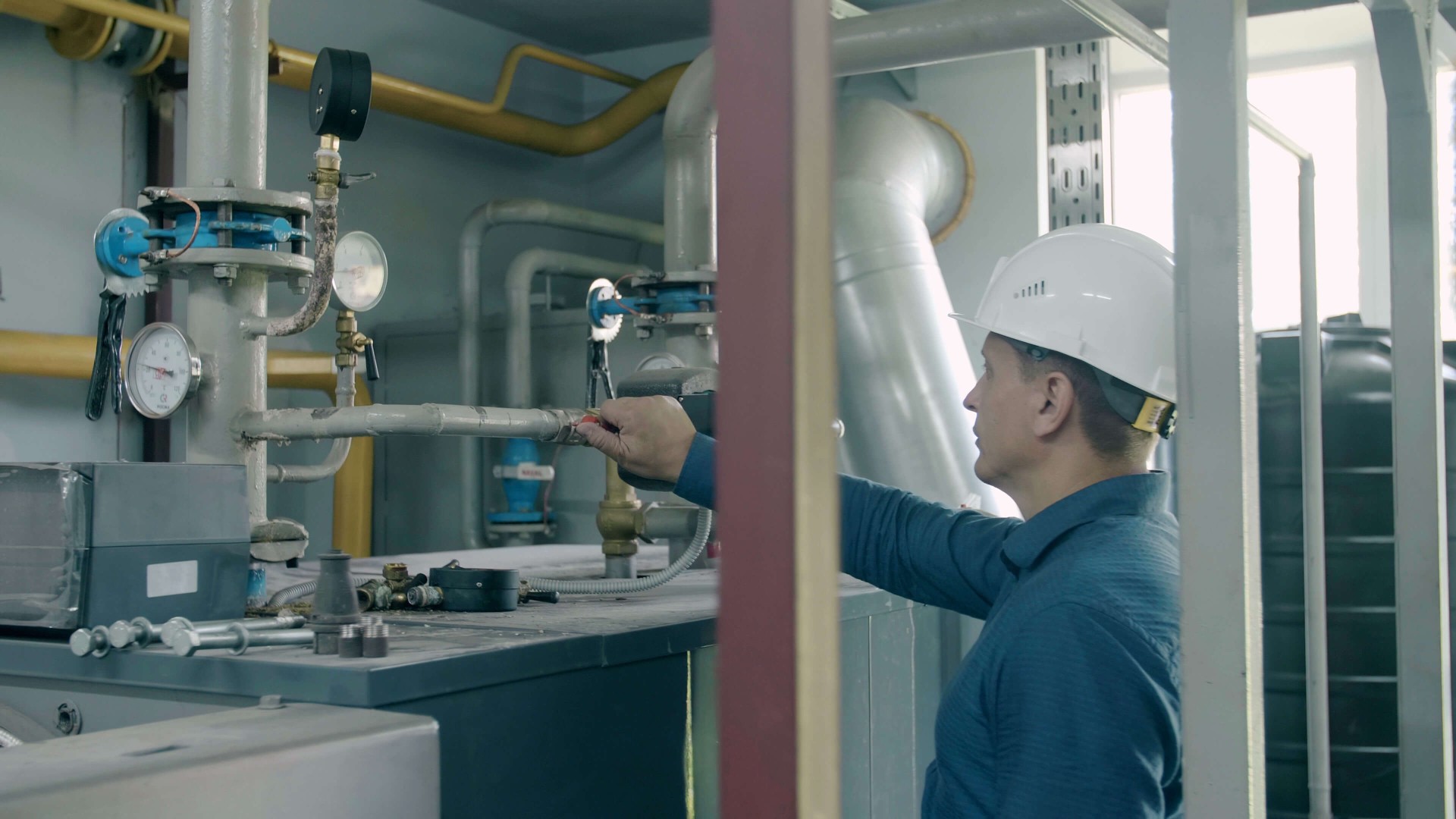 Selling a plumbing business - plumbing technician working on industrial pipes